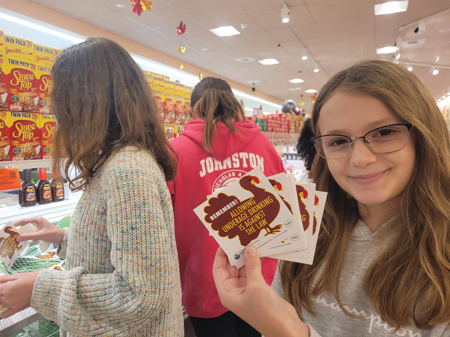 Ferri Middle School sixth-grader Lea Petrillo fans a big stack of stickers she and her fellow ATI members plan to paste to turkeys at Market Basket in Johnston.